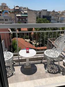 un balcón con 2 sillas y una mesa en el balcón en ACROPOLIS CASA Historical Centre Top Floor Luxury Suite 150 meters to Metro en Atenas