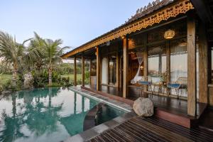 a house with a swimming pool in front of it at Airsania Ubud Antique Villas in Ubud