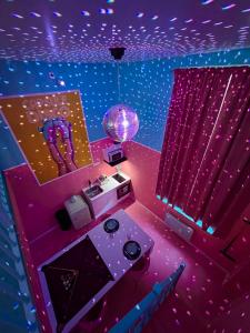 une chambre violette avec une boule disco dans l'établissement Funky House - Jacuzzi - Billard - Netflix & Home Cinéma - Nintendo switch & jeux, à Douai