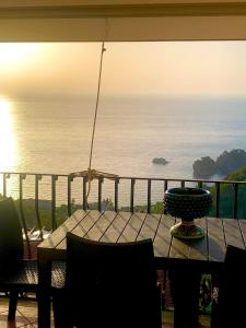 una mesa en un balcón con vistas al océano en Maison belle Vue, en Taormina