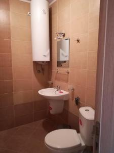 a small bathroom with a toilet and a sink at Sirena Holidays in Ravda
