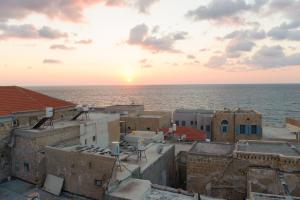 uma vista para o oceano a partir dos telhados dos edifícios em The Efendi Hotel Akko em Acre