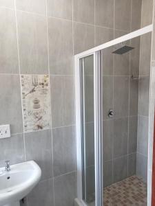 W łazience znajduje się prysznic i umywalka. w obiekcie La Bronze Guest Lodge w mieście Newcastle