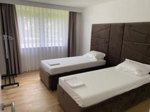 a hotel room with two beds and a window at Mia apartman Visoko in Visoko