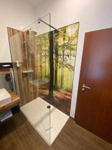 a shower with a glass door in a bathroom at Hotel Friedchen mit eigener Fleischerei in Artern