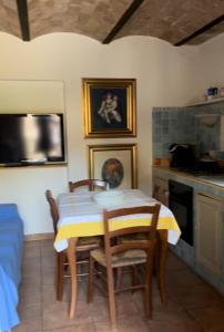 comedor con mesa y sillas y cocina en Casa Romano, en Manciano