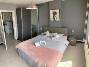 een slaapkamer met een groot bed en 2 handdoeken bij B&B Den Boskant in Zandbergen