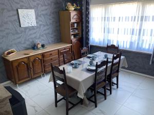 a dining room with a table and chairs and a window at B&B Den Boskant in Zandbergen