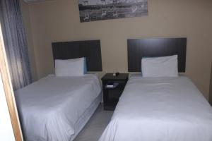 dwa łóżka siedzące obok siebie w pokoju w obiekcie La Bronze Guest Lodge w mieście Newcastle