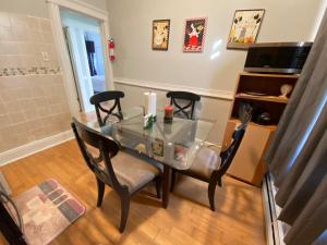 a glass table with four chairs in a room at 2cozy Apt W Fast Transportation To New York City in West New York