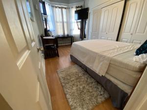 a bedroom with a bed and a door with a rug at 2cozy Apt W Fast Transportation To New York City in West New York