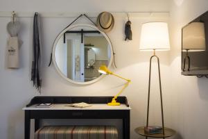a mirror and a lamp in a room at Market House - An Atlas Boutique Hotel in Tel Aviv