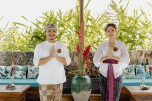 a man and a woman sitting in meditation in a living room at Airsania Ubud Antique Villas in Ubud +58 photos
