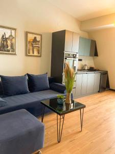 a living room with a blue couch and a table at Living Rooms in Skopje