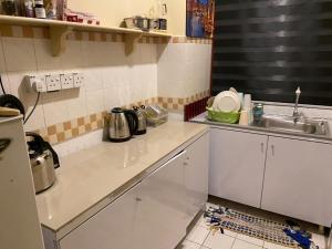 a kitchen with white cabinets and a sink at Port Dickson Paradise Lagoon Beachfront Apartment in Port Dickson