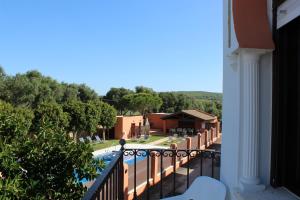 a balcony of a house with a pool and trees at Hostal Alhambra in Zahora