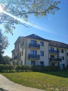 a large apartment building with a lawn in front of it at St.Gotthard Apartman in Szentgotthárd