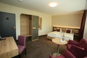 Hotel Münchner Hof في هيرفورد: غرفة فندقية بسرير وطاولة وكراسي