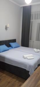a bedroom with two beds with blue pillows at Hotel Posta Khulo in Khulo
