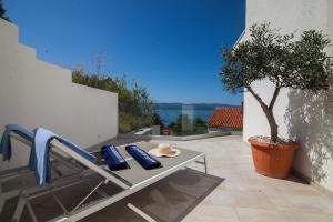 a patio with a table and chairs and a tree at Belado Residence Bol in Bol