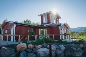 a red house with rocks in front of it at Abisko Mountain Lodge in Abisko