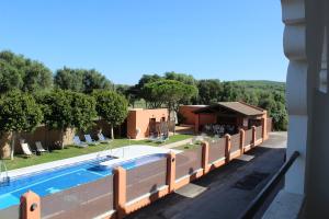a villa with a swimming pool and a house at Hostal Alhambra in Zahora