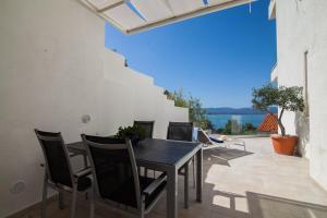 einen Tisch und Stühle auf einer Terrasse mit Blick auf das Wasser in der Unterkunft Belado Residence Bol in Bol