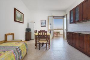 a bedroom with a bed and a table and chairs at Casa vacanza Mare Blu in Torre Lapillo