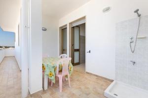 a bathroom with a table and two chairs and a shower at Casa vacanza Mare Blu in Torre Lapillo
