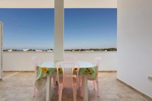 a dining room with a table and chairs and windows at Casa vacanza Mare Blu in Torre Lapillo