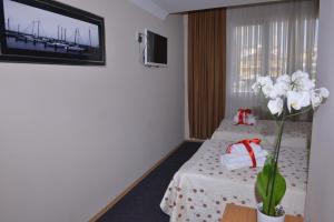 イスタンブールにあるKervan Hotel Pendikのベッド2台と花瓶が備わるホテルルームです。
