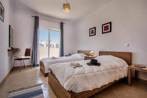 a bedroom with two beds and a large window at Felizalgarve by Algarve Villa Holidays in Albufeira +16 photos