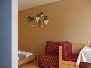 um quarto com uma cadeira e corações na parede em hotel Parco Pineta em Cavareno