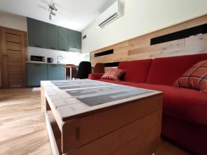 sala de estar con sofá rojo y mesa en Kasztanowe Wrota, en Kosewo