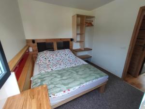 a small bedroom with a bed and a table at Kasztanowe Wrota in Kosewo