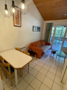 una sala de estar con un sofá y una mesa en Séjour Moliets plage, en Moliets-et-Maa