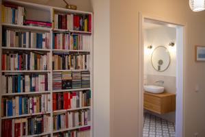 a book shelf filled with books next to a bathroom at Kapitänshaus Luv & Lee in Wustrow