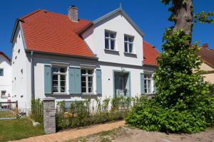 a white house with an orange roof at Kapitänshaus Luv & Lee in Wustrow