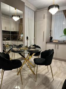 een eetkamer met een glazen tafel en stoelen bij Golden Apartment in Oradea