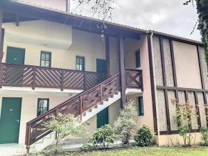 vistas al exterior de un edificio con una escalera de madera en Séjour Moliets plage, en Moliets-et-Maa
