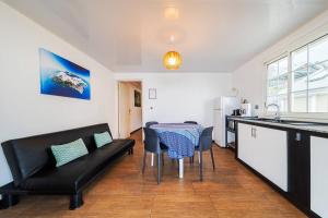 eine Küche und ein Wohnzimmer mit einem Sofa und einem Tisch in der Unterkunft Kaz Noulafé in Saint-Leu