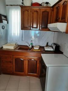 Elle comprend une petite cuisine avec des placards en bois et un évier. dans l'établissement Holiday Home in Sarti, Chalkidiki, à Sarti