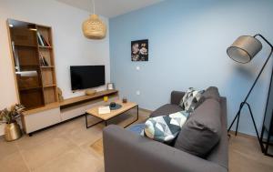 een woonkamer met een bank en een tv bij Vera's Lapad suite in Dubrovnik