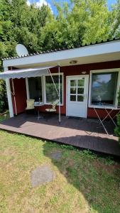 アールベックにあるBungalow (hälfte) Backbord Ahlbeck (Usedom)のテーブルと傘付きのデッキのある家