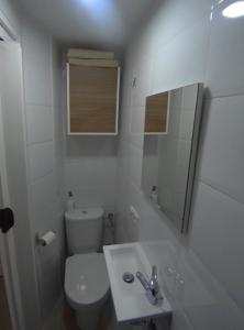 een witte badkamer met een toilet en een wastafel bij Estudio con encanto a metros de la playa in Sitio de Calahonda