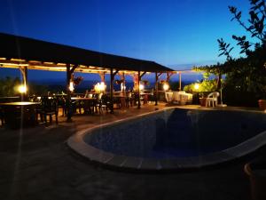 a patio with a swimming pool at night at Family Hotel Arbanashka Sreshta in Arbanasi