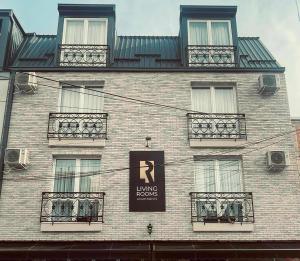 a large brick building with balconies and a sign on it at Living Rooms in Skopje