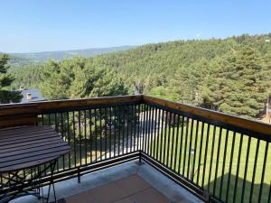 d'un balcon avec un banc et une vue sur les montagnes. dans l'établissement Apartament Orbis La molina, à La Molina