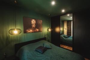 Dormitorio verde con cama y espejo en Apartament Leśny-Cedzyna no62 TARGI Kielce Rowery !!! en Kielce