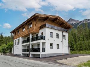 un grande edificio bianco con tetto in legno di Appartements Steinberg a Steinberg am Rofan